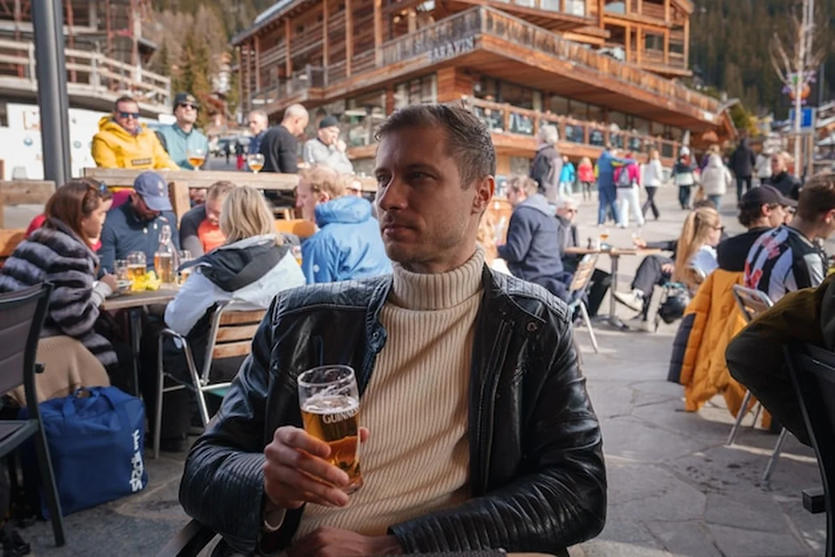 Mężczyzna trzyma piwo Guinnessa w barze na świeżym powietrzu