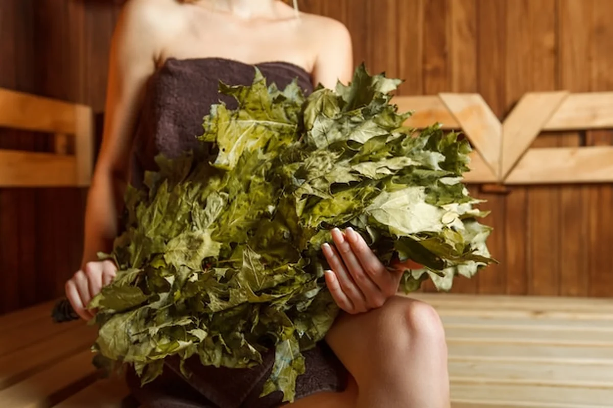 Kobieta w saunie z miotłą w rękach